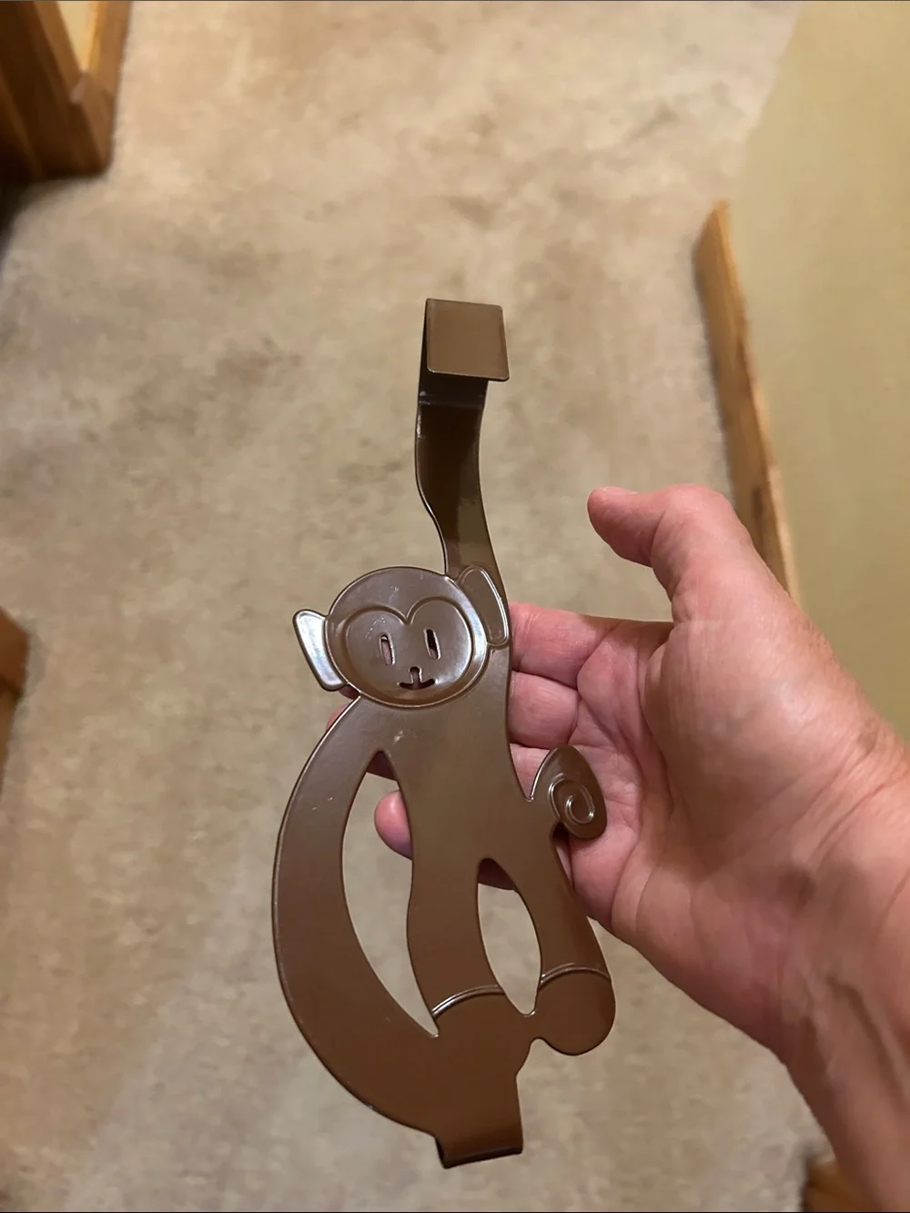 A set of 3 whimsical brown metal monkey over-the-door hooks